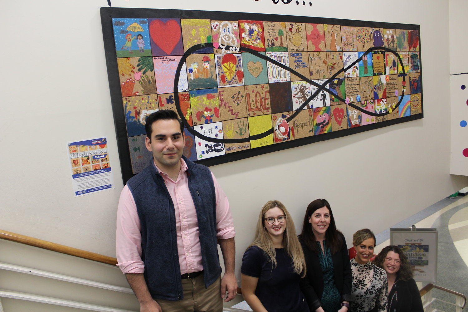 Assemblyman Jarett Gandolfo, children services librarian Olivia Manghini, special education coordinator Joyce Thompson-Haas, community relations manager Michelle Cayea, and library director Danielle Paisley stand in front of the Patchogue-Medford Library’s “Kindness Is” mural.
